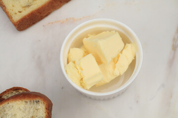 Butter pieces in bowl on white background. Farm dairy products.  Selective focus.