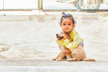 Little girl playing with her pet. Latina girl spending time with her dog and her grandfather....