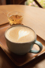 cup of coffee latte with hot tea on wooden tray