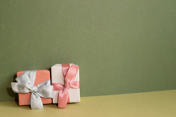 Pink gift box on table. khaki green background - Powered by Adobe