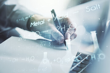 Double exposure of creative chemistry concept with hand writing in notebook on background with laptop, research and development concept