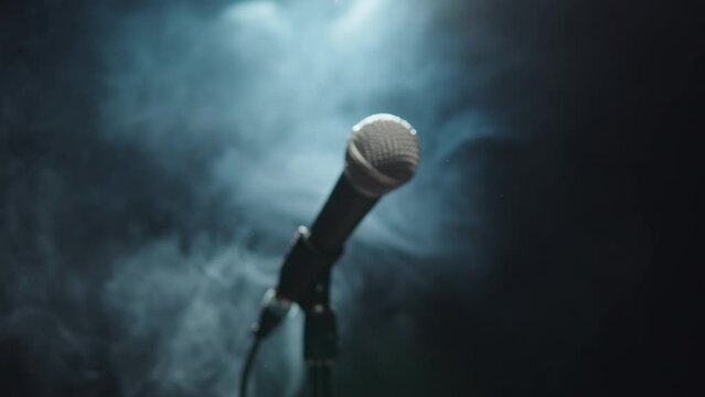 Microphone close-up, mic with smoke and black background. Karaoke singing, nightlife club or bar. Music, musical concert.