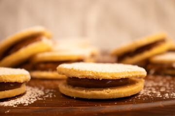 Close up of a group of cookies with powdered sugar on top and filled out with some caramel