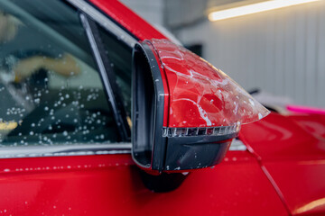 Installs vinyl film for protect paint body side mirrors red car