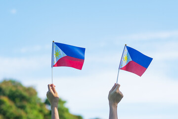 hand holding Philippines flag on nature background. 12th June of Independence day and happy...