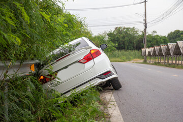 A white car get acciident out of the road. Insurance claims concept.