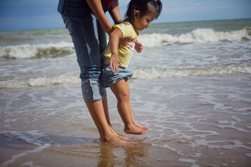 Mother and baby feet on sand summer beach. Family insurance support concept.