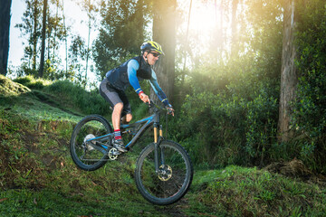 Fototapeta premium Man jumping in a forest on his mountain bike