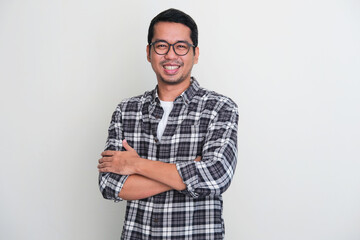 Adult Asian man standing confident with arms crossed showing happy expression
