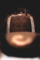 Whiskey barrels filled with beer in dark cellar.