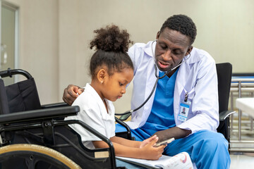 African american doctor is diagnosis the disability kid on wheelchair by using stethoscope for lung...