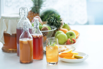 Homemade fermented raw Kombucha tea, healthy natural probiotic flavored drink, glass of Kombucha drink with lemon on white background