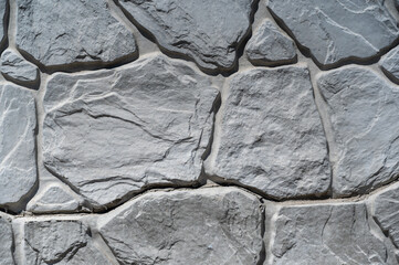 Texture of a gray stone wall. Ornate cracks and patterns in the stone surface. Abstract multitasking background