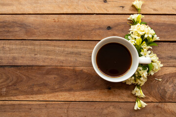 hot coffee espresso with white flowers jasmine arrangement flat lay postcard style on background wooden