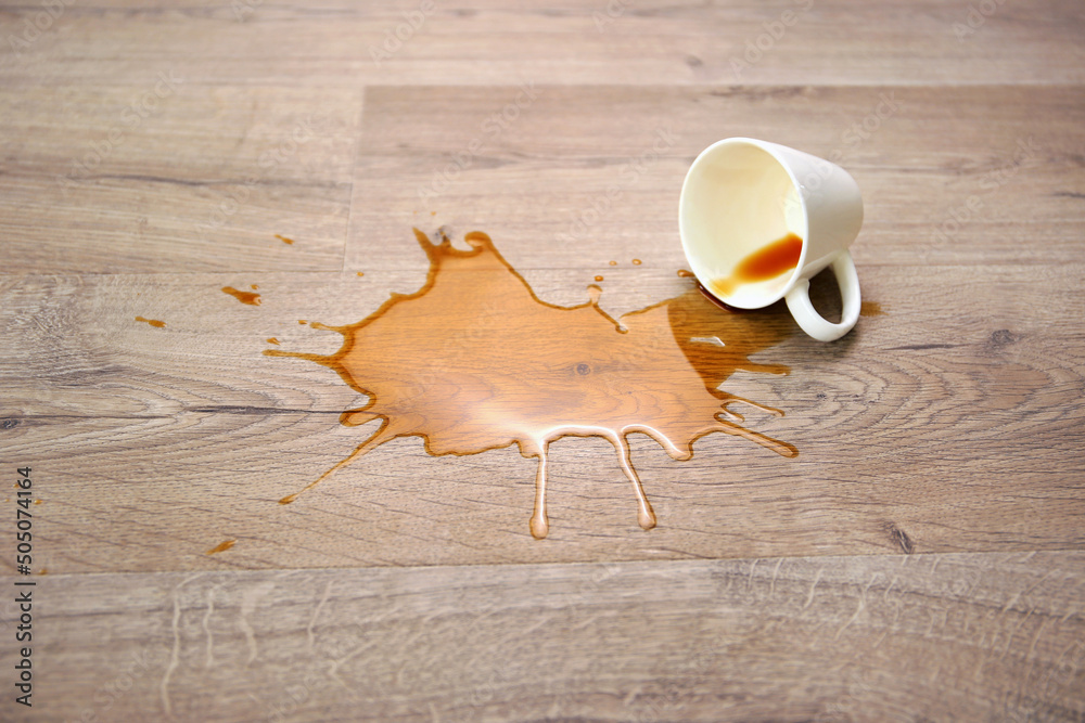 Wall mural A cup of coffee fell on laminate, coffee spilled on floor.