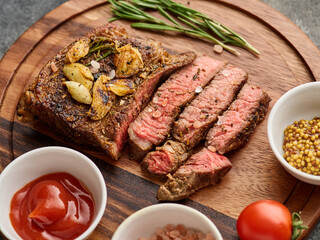 Medium rare Ribeye steak or beef steak on the wooden tray with herbs