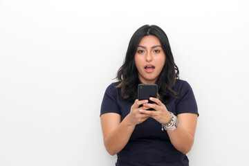 Joyful young latin woman pointing at smartphone in hand, online shopping application on a white background