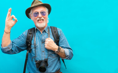 Old male pensioner with camera and backpack is ready to traveling- Funny old male pensioner with...