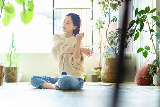 部屋でストレッチする女性