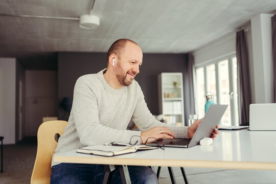 Man sitting in front of his laptop listening to music