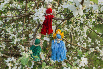 Fototapeta na wymiar Group of three handmade faceless doll knitted from a red, green and blue threads. Macrame technique. Eco decoration.