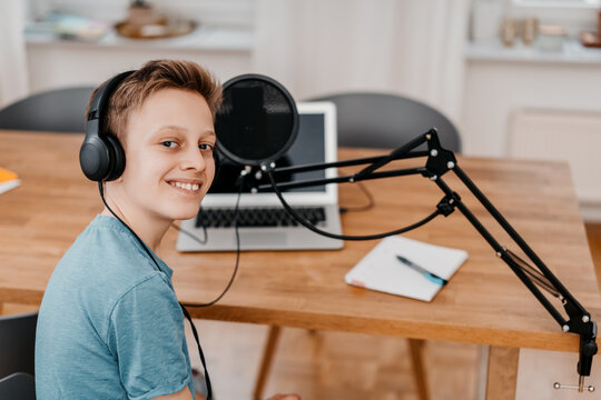 schoolboy sits in front of his laptop and records a podcast