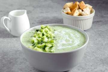 Cucumber Gazpacho. Green fresh cold summer soup on gray background. concept of vegan cuisine