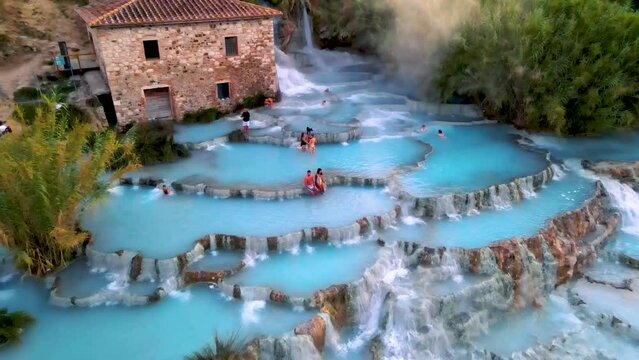 Toscane Italy, natural spa with waterfalls and hot springs at Saturnia thermal baths, Grosseto, Tuscany, Italy aerial view on the Natural thermal waterfalls couple at vacation at Saturnia Toscany