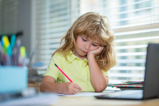 Tired schoolboy while doing homework. Child writing homework in school class. Funny child girl doing homework writing and reading at home. Little student at desk in school classroom.