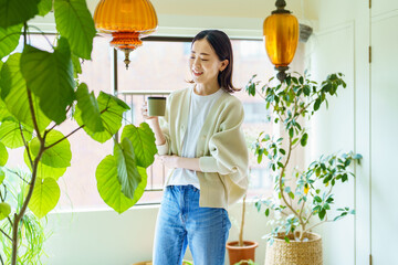 観葉植物に囲まれてリラックスする女性