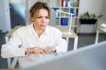 Angry business woman looking excitedly at computer screen