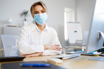 Fototapeta na wymiar Female office worker in a medical mask