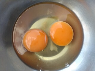 Raw chicken eggs in a stainless steel bowl