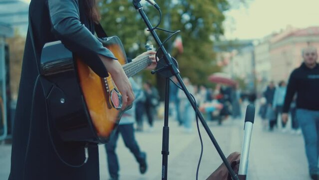  A street musician plays the guitar and sings for passers. Warsaw's palace Square in the center of the old city
