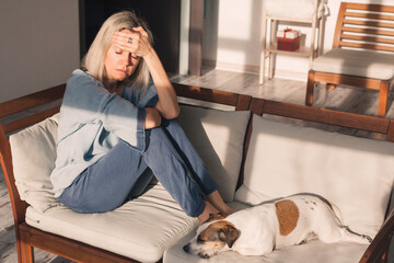 Depressed lonely unhappy mental woman sitting alone on the sofa feel stress