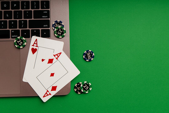 Playing cards with aces and chips on a laptop on with copy space. Top view. Gambling online, casino, bets concept