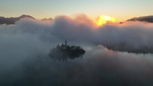 Lake Bled on a beautiful spring morning with mist and low clouds at sunrise. Lake Bled is located in Slovenia, near the Julian Alps. It's an Alpine jewel with a little island in the middle of the lake