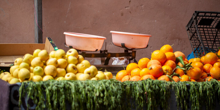 Báscula de pesaje junto a manzanas y naranjas en el mercado