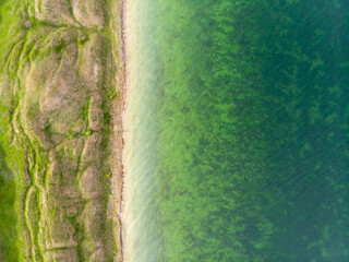 Aerial view of beautiful surrealistic terrain with hills near calm green water river estuary in Ukraine