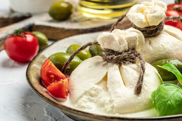 handmade soft Italian cheese served with olives, cherry tomatoes, fresh basil leaves. white balls...