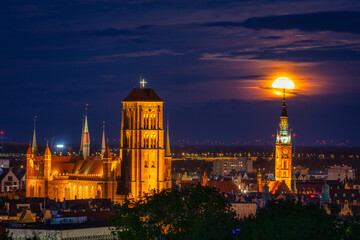 A full moon rising over the city of Gdansk at dusk. Poland