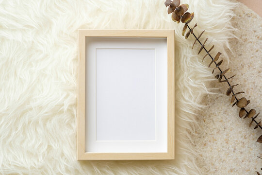 blank photo frame eucalyptus on white fur and marble stand background