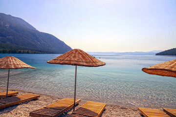 wicker umbrella wooden chaise longue by the sea