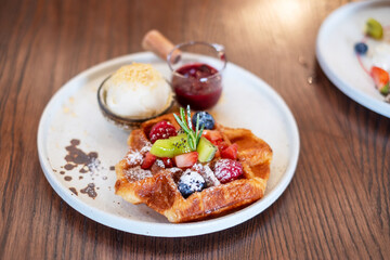 Woman eating dessert with fresh berries and fruit at cafe