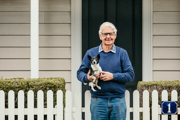 Elderly man with small dog in the street.