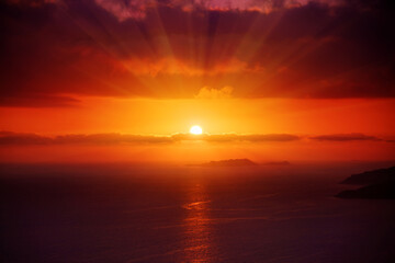 Great dramatic view. Red sun in the clouds. Meditative calmness and greatness. Amazing sky panorama. Colorful sunset in the evening sky. Clouds illuminated by the setting sun