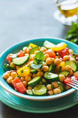 Chickpea salad with tomatoes, cucumber, parsley, onions in a plate, selective focus. Healthy vegetarian food, oriental and Mediterranean cuisine. Chick peas salad