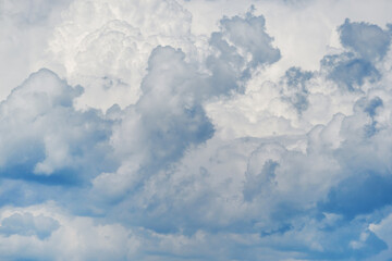 Summer sky. White clouds in the blue sky. Heaven and infinity. Beautiful bright blue background. Light cloudy, good weather. Curly clouds on a sunny day