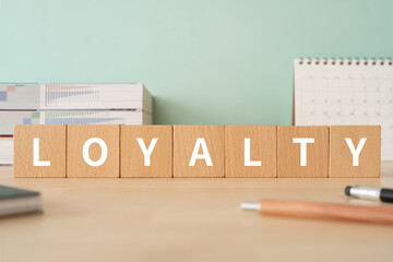 忠義・忠誠のイメージ｜「LOYALTY」と書かれた積み木が置かれたデスク