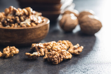 Peeled walnut kernels on black table.